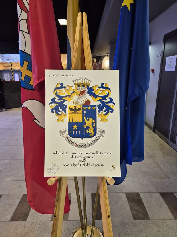 Party per pale: 1 per fess indented perlong Or and Azure overall on a fess Azure a mullet Or, and on a chief cousu Or an eagle displayed, a crown Or above [for Tamburelli]; 2 Azure, a lion rampant Or supporting a lance palewise Argent, in chief three mullets Or [for Lanzara]. Crest: Upon a helm, with visor bars Or, lined Gules, with a wreath Or and Azure, a crown of an Italian Count. Mantling: Azure doubled Or. Motto: �Virtus Honor Imperium�.